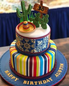 a colorful birthday cake with cactus decorations on top