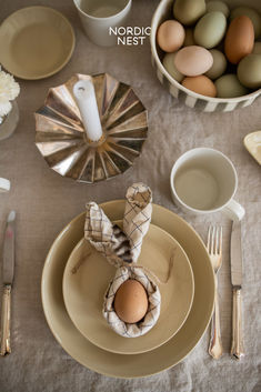 a table set with eggs, silverware and napkins