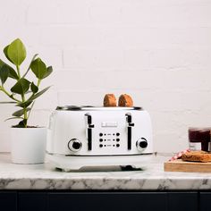 a toaster sitting on top of a counter next to a potted plant