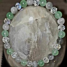 Experience timeless elegance and natural beauty with our Aventurine and Cloudy Quartz Crystal Bracelet. This exquisite piece is designed to elevate your everyday look with its mesmerizing charm, making it the perfect accessory for any occasion. Crafted from genuine Aventurine and Cloudy Quartz crystal, this bracelet boasts an intricate pattern of smooth, polished stones. The subtle green hues of the Aventurine complement the cloudy white tones of the quartz perfectly, creating a serene contrast that is sure to captivate all who lay eyes upon it. The combination of these two stones creates a powerful synergy that promotes harmony and balance within yourself. The Aventurine is known for its ability to soothe anxiety while enhancing your confidence by imbuing you with a sense of inner strengt Healing Jade Crystal Bracelet With Natural Stones, Elegant Aventurine Beaded Bracelets For Healing, Aventurine Crystal Bracelet With Natural Stones For Meditation, Jade Crystal Bracelet With Gemstone Beads For Healing, Amazonite Gemstone Beads Bracelet For Healing, Elegant Amazonite Bracelet For Healing, Spiritual Amazonite Crystal Bracelet For Healing, Healing Aventurine Crystal Bracelet, Quartz Gemstone Beads Bracelet For Healing