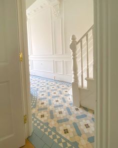 an empty hallway with blue and white tiles on the floor