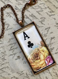 a necklace with a ace playing card and a rose on it's front side