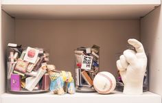 a baseball glove and other items sit on a shelf