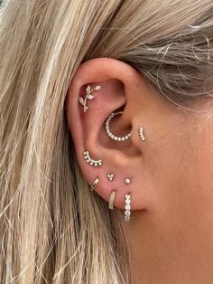 a woman with blonde hair wearing three different ear piercings