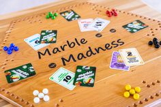 a wooden board game that says marbles and mardi gras on the side