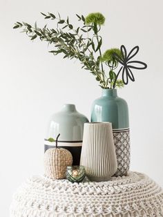 two vases sitting on top of a white table