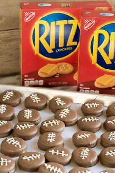 two boxes of ritz crackers with chocolate football cookies in the foreground and one box of peanut butter