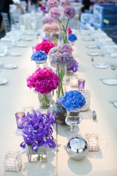 a long table with flowers and candles on it