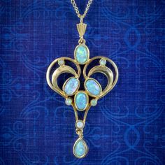 A beautiful Edwardian inspired necklace fashioned in Sterling Silver and gilded in 18ct Yellow Gold. It features a fabulous heart shaped pendant collet set with ten, mesmerising Cultured Opals which shimmer and change colour as they catch the light.   It's very eye catching and a wonderful, distinct design.   WEIGHT: 3.8 grams - 4.8 grams with chain   PENDANT MEASURES: Height 45mm x Width 24mm x Depth 3.5mm CHAIN MEASURES: 18 inches METAL: Sterling Silver, gilded in 18ct Gold STONES: Cultured Op