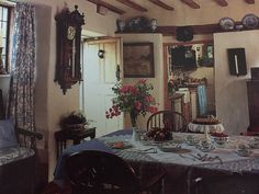 an old fashioned dining room with flowers on the table