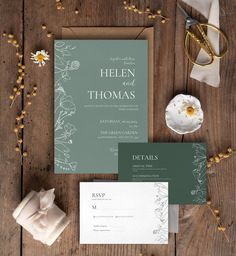 the wedding stationery is laid out on a wooden table