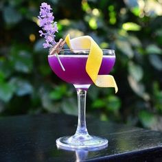 a purple drink with lemon wedges and lavender sprigs