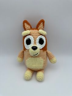 a crocheted stuffed animal with big eyes and a brown dog's head