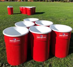 several red trash cans sitting in the grass