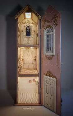 an open doll house with its door opened and the interior painted pink, gold and white