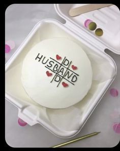 a cake in a plastic container with the words husband and wife written on it next to a pair of scissors