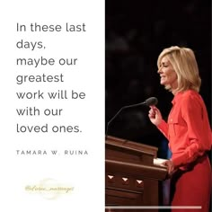 a woman standing at a podium in front of a microphone with a quote on it