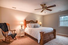 a bed room with a neatly made bed and a chair