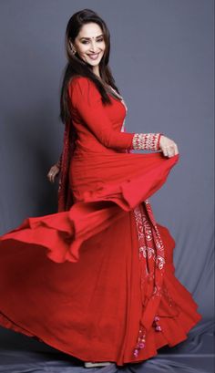 a woman in a long red dress posing for a photo with her hands on her hips