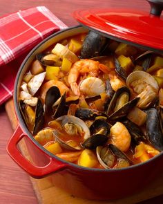 a red pot filled with seafood and mussels