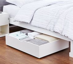 a white bed with two drawers underneath it