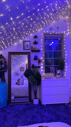 a bedroom with purple lights and a mirror on the wall, next to a bed