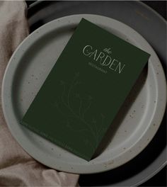 a green book sitting on top of a white plate