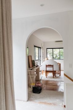 an archway leading into a living room with a table and chairs in the corner,