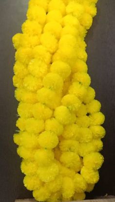 yellow pom - poms hanging from the side of a wall