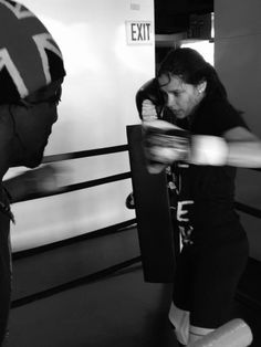 two people in a boxing ring one is punching the other