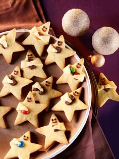 some cookies are arranged in the shape of stars on a plate next to christmas decorations