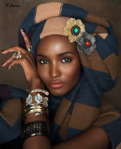 a woman with rings and bracelets on her head, wearing a scarf over her head