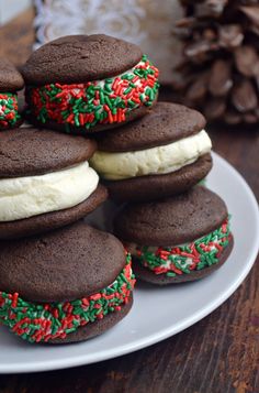 chocolate cookies with frosting and sprinkles are stacked on top of each other