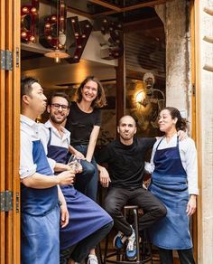 a group of people standing around each other in front of a restaurant