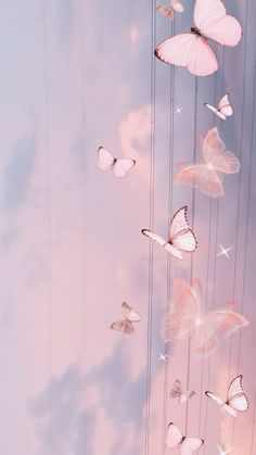 pink butterflies are flying in the sky with strings attached to it's sides,