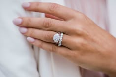 a close up of a person's hand with two rings on their fingers