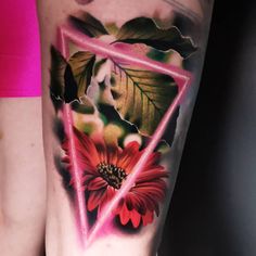 a woman's leg with a flower and triangle tattoo on it