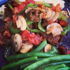 a blue plate topped with green beans and mushrooms