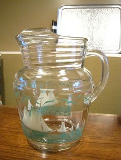 a glass pitcher filled with water on top of a wooden table