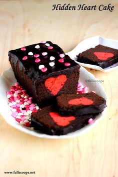 chocolate cake with red and pink sprinkles on a white plate next to another piece of cake