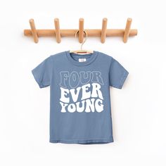 a t - shirt that says four ever young hanging on a clothes rack with wooden hangers