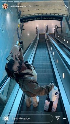 a woman is sitting on an escalator with her luggage