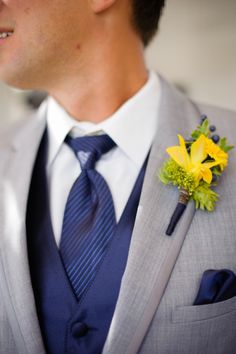 a man in a suit and tie with a boutonniere on his lapel