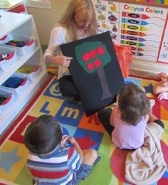 three children sitting on the floor playing with an art project