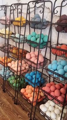 there are many different colored eggs in baskets on the wall and behind them is a white brick wall