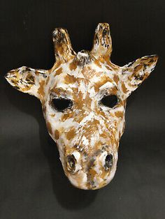 a giraffe mask is shown on a black background