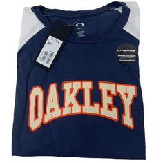 Classic Style Merges With Comfort In This Oakley Sport ¾ Tee. Hydrolix Poly/Cotton Fabric, Along With A Ribbed Collar And Flat Seams Help Keep You Dry And Comfortable, And The Varsity-Style Oakley Script Up Front Gives You A Stylish Edge. 85% Polyester 15% Cotton Brand New With Tags Authentic Oakley Long Sleeve Summer Shirt For College, Blue Summer Shirt For College, Casual Blue T-shirt With 3/4 Sleeves, Casual Blue 3/4 Sleeve T-shirt, Usa Tee, Varsity Style, Button Down Shirt Mens, Oakley Men, Quarter Zip Sweatshirt