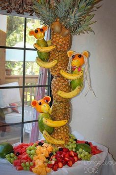 there are many fruits arranged in the shape of monkeys on top of a pineapple