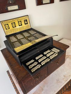 an old typewriter sitting on top of a wooden table next to two framed pictures