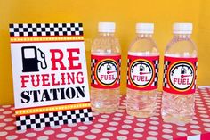 four bottled water bottles sitting on top of a table next to a sign that says fuelling station